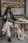 West Coast dog owner sitting at a café patio with her Labrador — Ritual Gear lifestyle